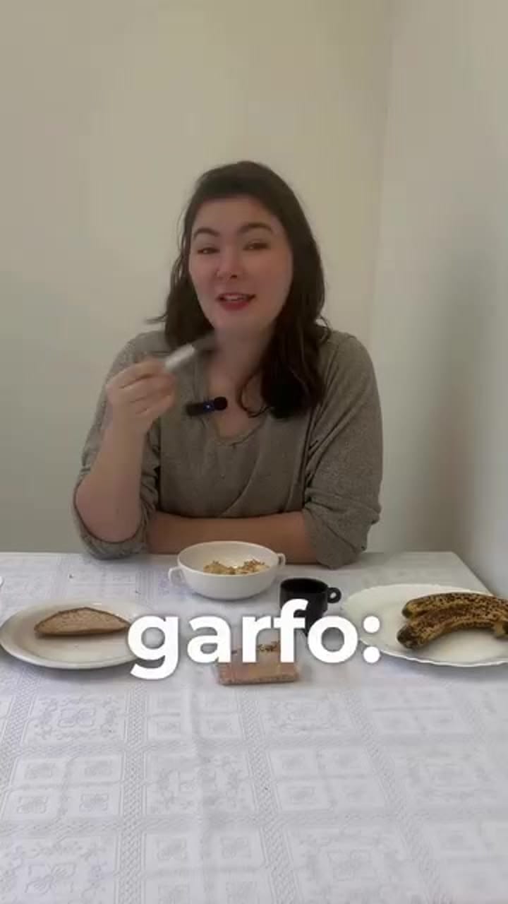 Criança pequena tentando usar o garfo para pegar comida do prato
